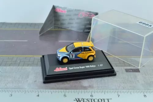 Yellow 1:87 diecast rally car with black accents on display base