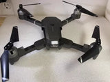 Attop quadcopter drone with four arms and propellers, black body and landing legs