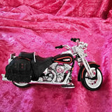 Diecast model of Harley Davidson motorcycle with black seat and chrome engine, front wheel visible