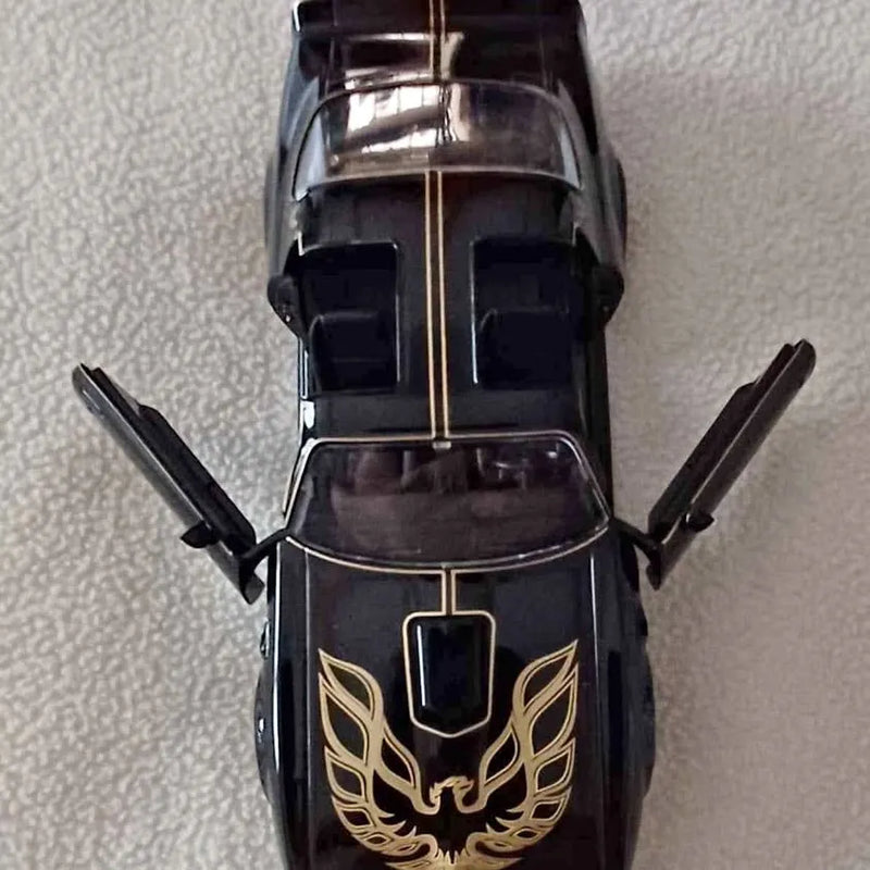 Black diecast car with gold flame emblem and gold-striped hood, front view