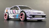White diecast model car with pink wheels and blue stripe, front 3/4 view