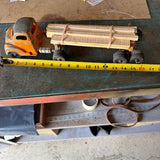 Vintage orange diecast log truck with wooden log load on open trailer