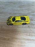 Yellow diecast sports car model with black flame decals, silver wheels