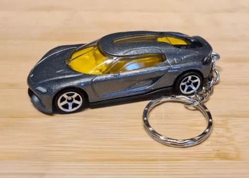 Diecast model car keychain with dark gray body, yellow accents, and chrome key ring