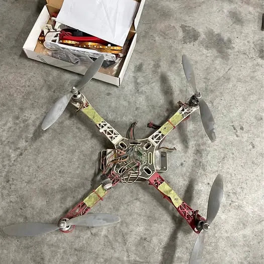 Quadcopter drone with four propellers, exposed frame and colorful wiring