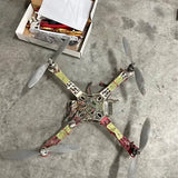 Quadcopter drone with four propellers, exposed frame and colorful wiring