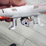 White quadcopter drone underside with camera module and front prop arms