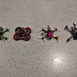 FPV drone set of four with red prop rings, pink center, and black frame