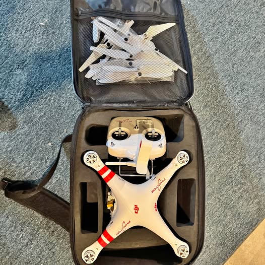 DJI Phantom drone, white quadcopter with red striped arms, in hard carrying case