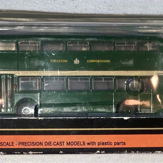 Green die-cast model bus with windows and side text reading Stockton Corporation