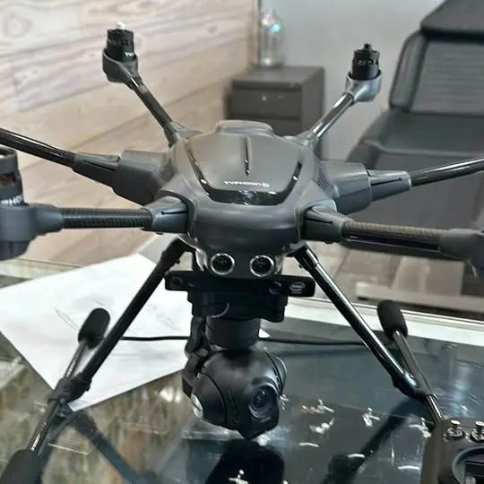 Gray quadcopter drone with camera gimbal and four extended landing arms