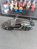 Diecast sports toy car with dark gray body, black details, and green stripe accents