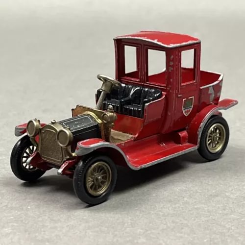 Red vintage diecast car with open cabin and detailed front engine and grille