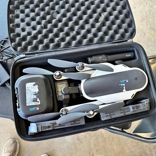 Folded quadcopter drone with propellers in hard shell carrying case