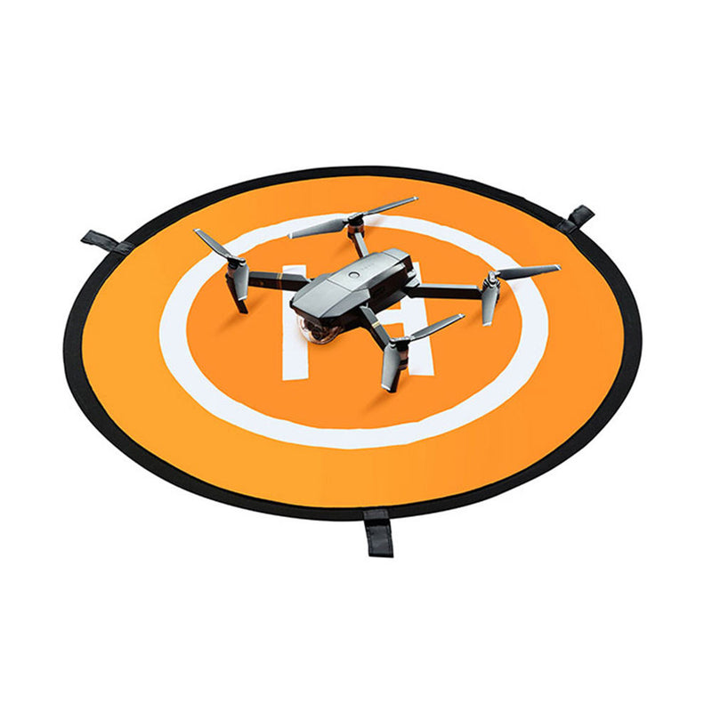 Round orange drone landing pad with black trim, straps, and drone centered