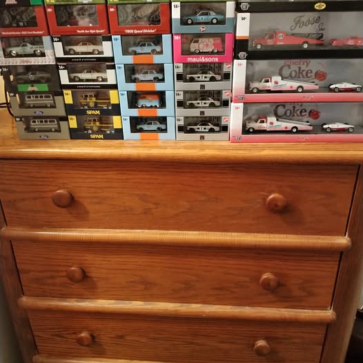 Boxed 1/64 scale diecast cars on display shelf