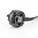 Brushless drone motor with circular housing, copper windings, mounting holes, and lead wire