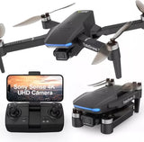 Black quadcopter drone with blue light and controller showing 4K UHD camera