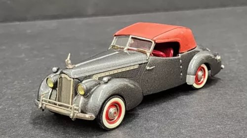 Gray diecast classic car with orange roof, red interior, and whitewall tires