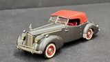 Gray diecast classic car with orange roof, red interior, and whitewall tires