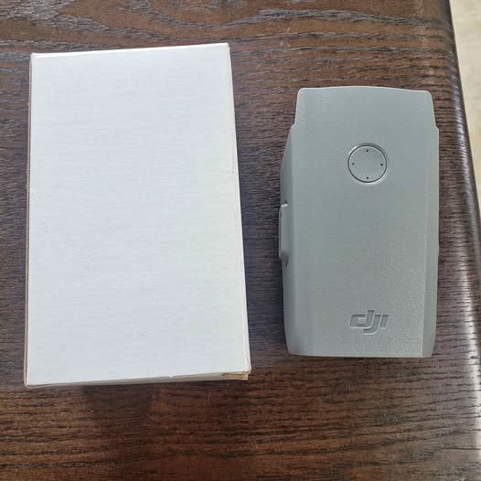 DJI Mavic drone battery with DJI logo and small indicator button, light gray