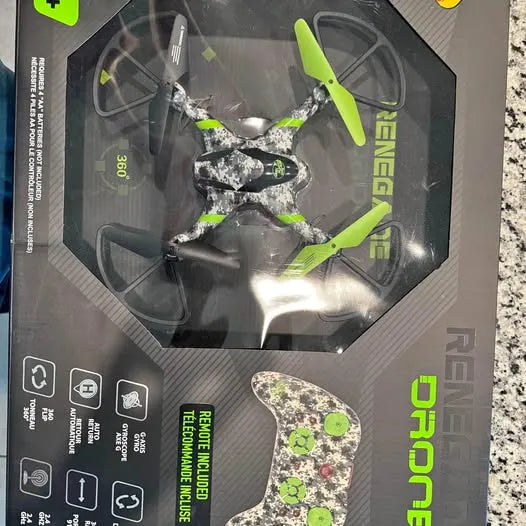 Green and black quadcopter drone in retail box, propellers visible