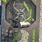 Green and black quadcopter drone in retail box, propellers visible