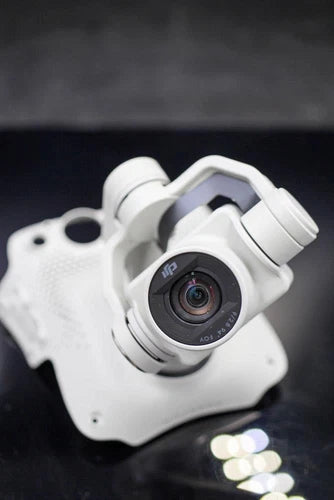 White camera gimbal with mounted lens and circular housing