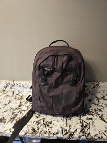 Brown padded camera backpack with front compartments and top handle