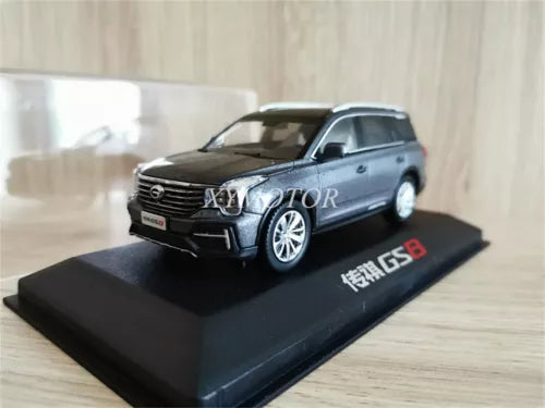 Dark gray SUV diecast model car with chrome grille on black display base
