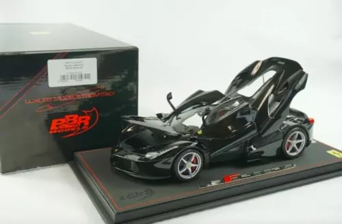 Black diecast Ferrari LaFerrari model car with open parts, on display base