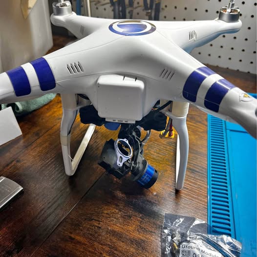 White quadcopter drone with blue stripe accents and front camera housing