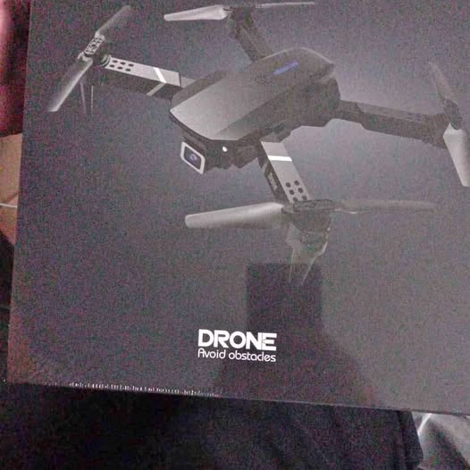 Obstacle-avoiding drone with propellers shown on product box, dark gray