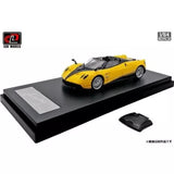 Yellow diecast mini roadster car with black roof on black display base, 1/64 scale