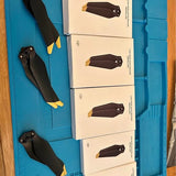 Drone propeller set with black blades and yellow tips in plastic tray