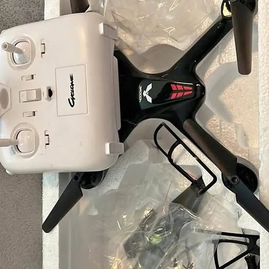 Quadcopter drone with black arms, front LED, and protective prop guards