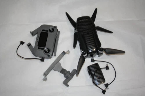 Foldable quadcopter drone with four propellers, dark body, plus controller