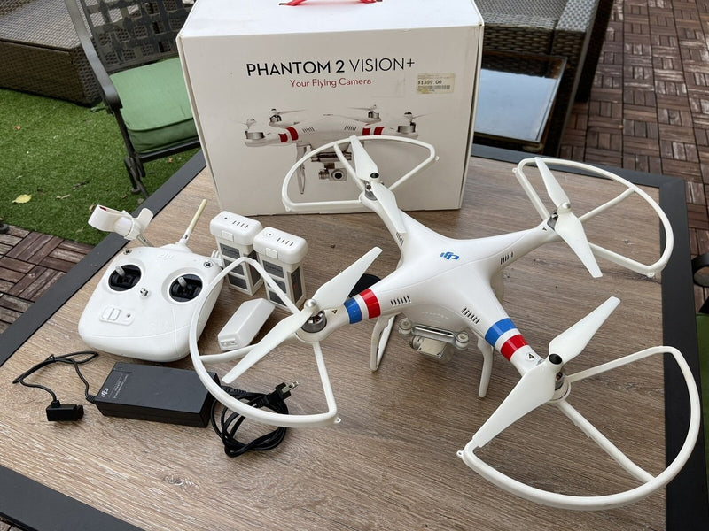White quadcopter drone with remote controller and charging cables