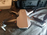 Folded white quadcopter camera drone with propellers visible