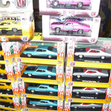 Assorted diecast car models in retail boxes, including teal and gray cars