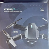 Foldable drone with remote controller, four-propeller design shown on packaging