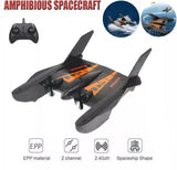 Spaceship-shaped RC airplane drone with remote controller, dark gray & orange markings