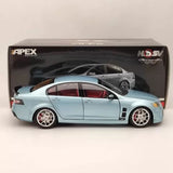 Diecast model car, light blue coupe with white wheels, front and side view