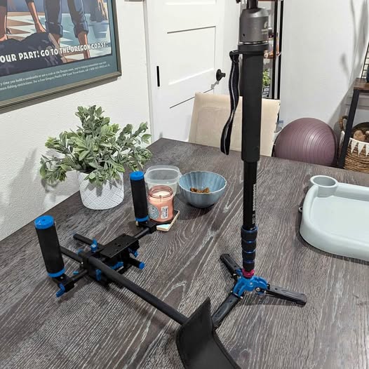 Black drone camera rig with tripod mount and blue clamps
