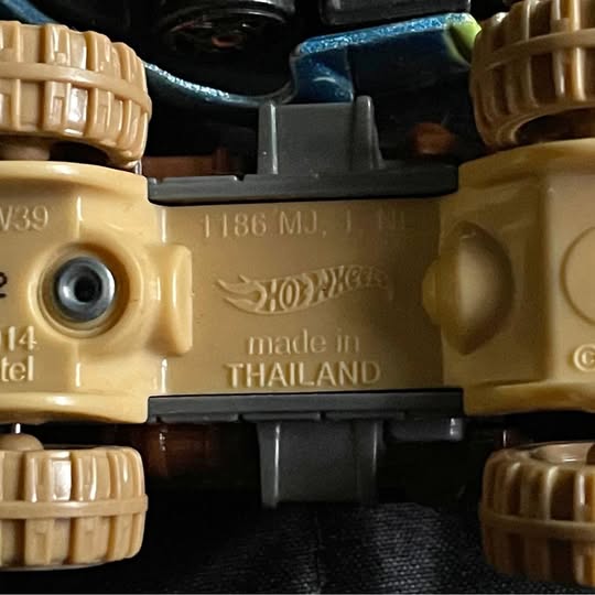 Hot Wheels Batmobile diecast car, tan body, front close-up with HotWheels logo