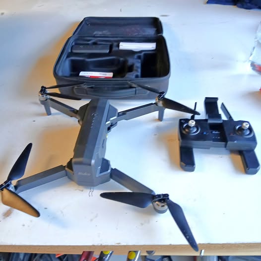 Black foldable drone with remote controller, quadcopter design