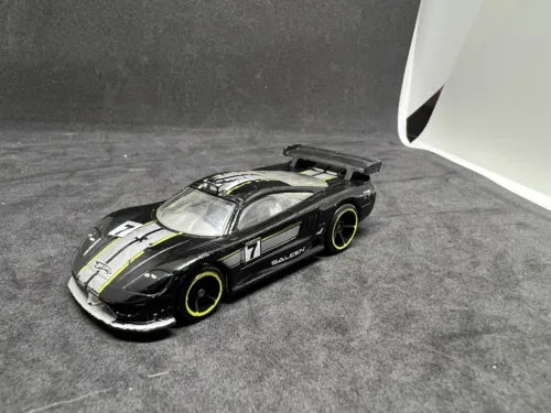 Diecast race car, black and white with #7 and yellow rims, front 3/4 view