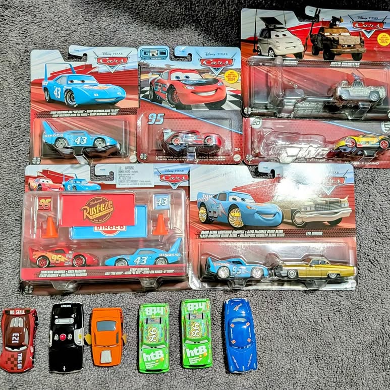 Diecast toy cars in blister packaging, with race-themed designs and cars inside