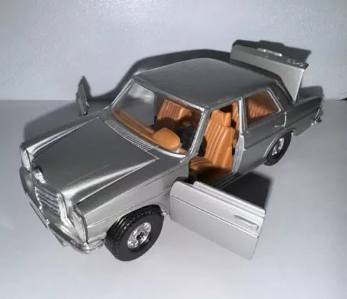 Silver-grey diecast sedan model car with doors open, showing orange seats.