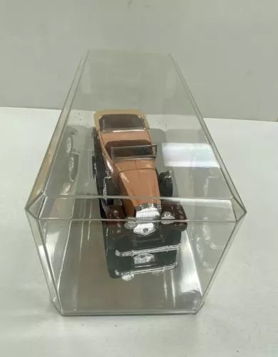 Diecast assembled car model with tan seats and brown top in clear display case